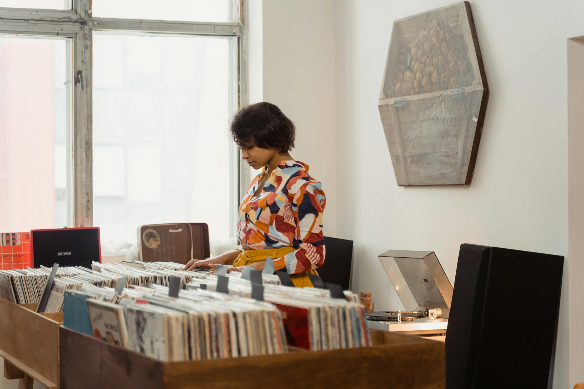 Vinyl records and music equipment arranged on a desk in a creative workspace