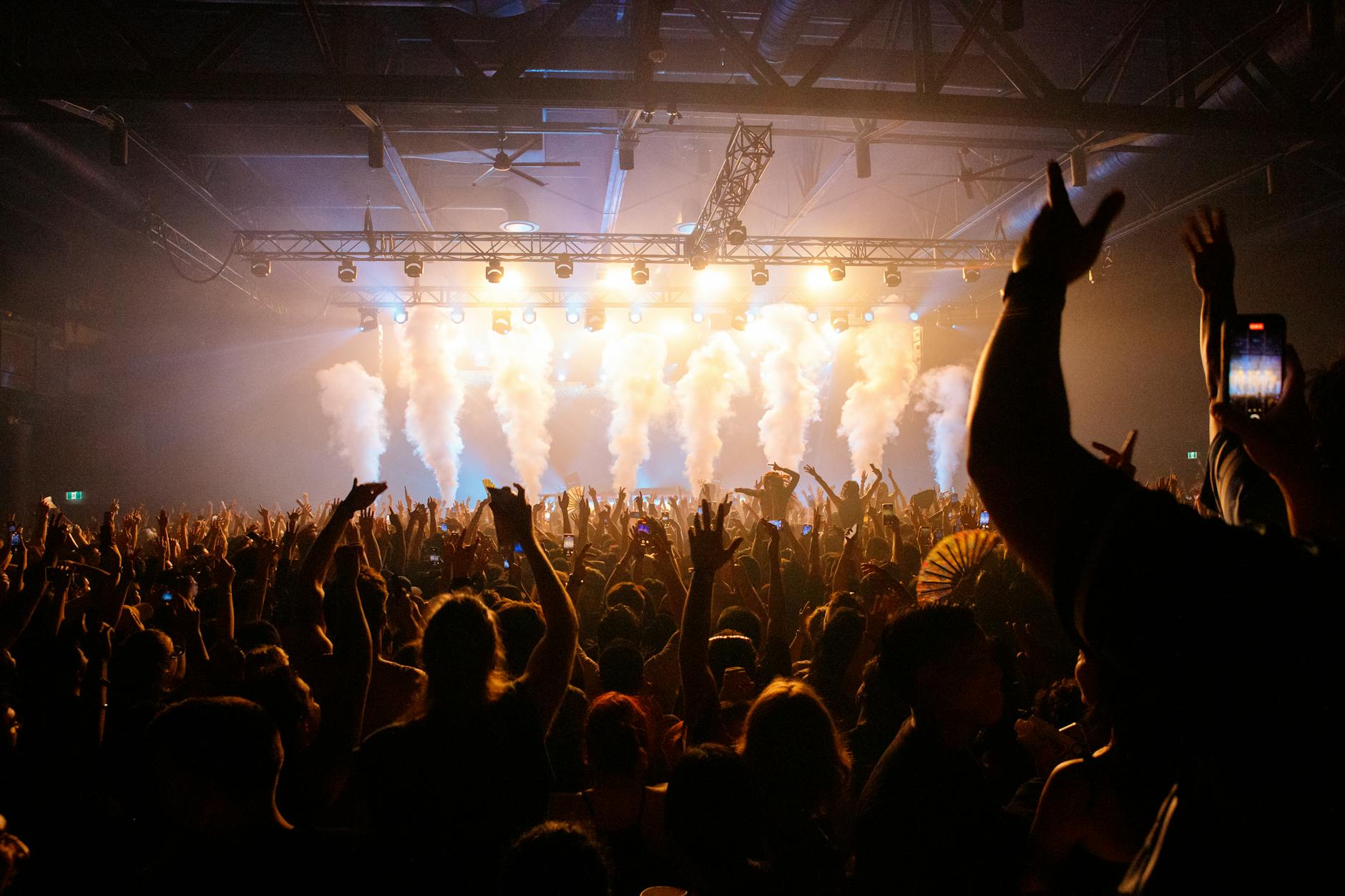 Close-up of concert lighting rig casting colored ambient light across a stage