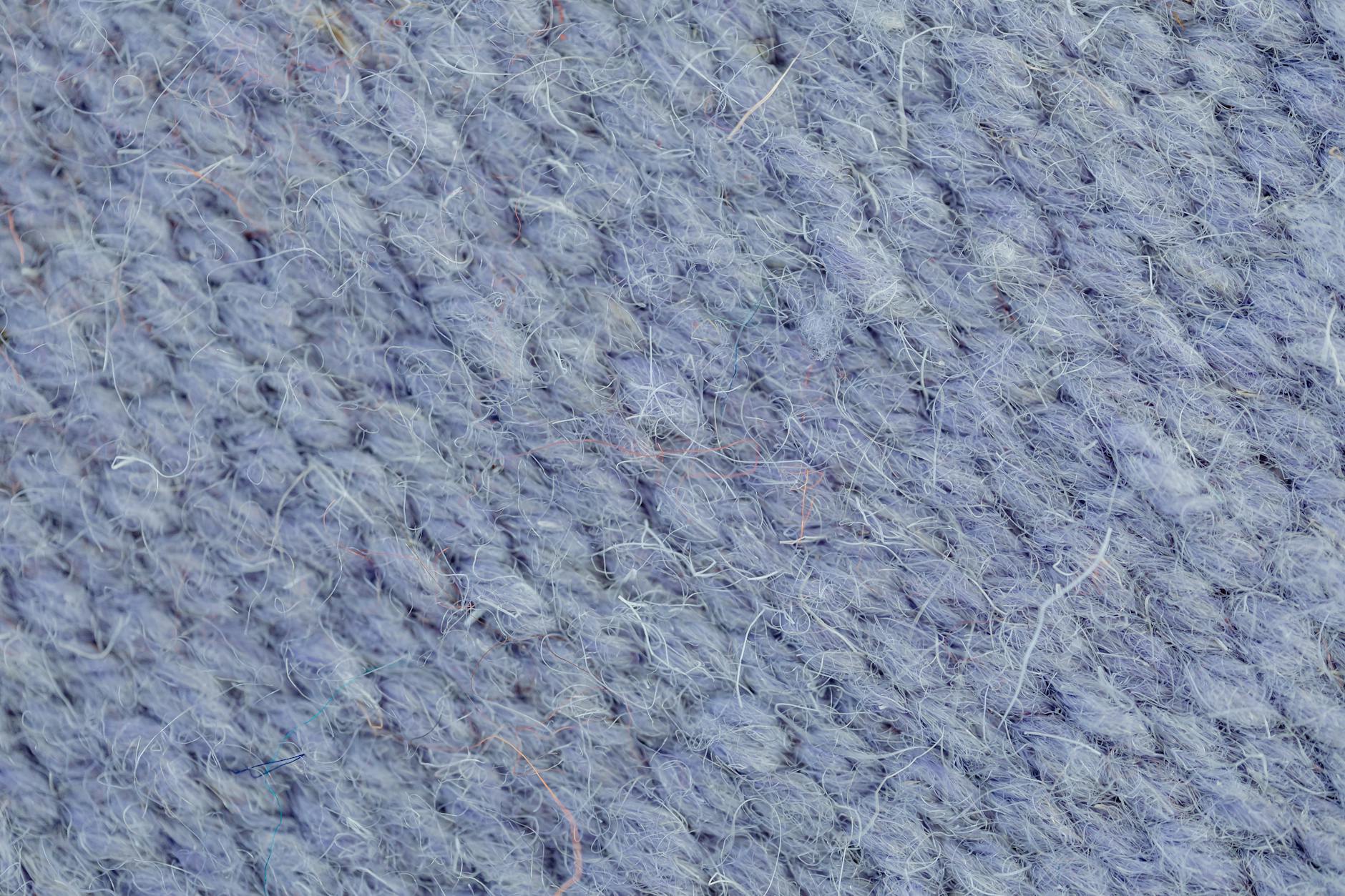 Close-up texture of fine knitted cashmere fabric in a soft neutral color