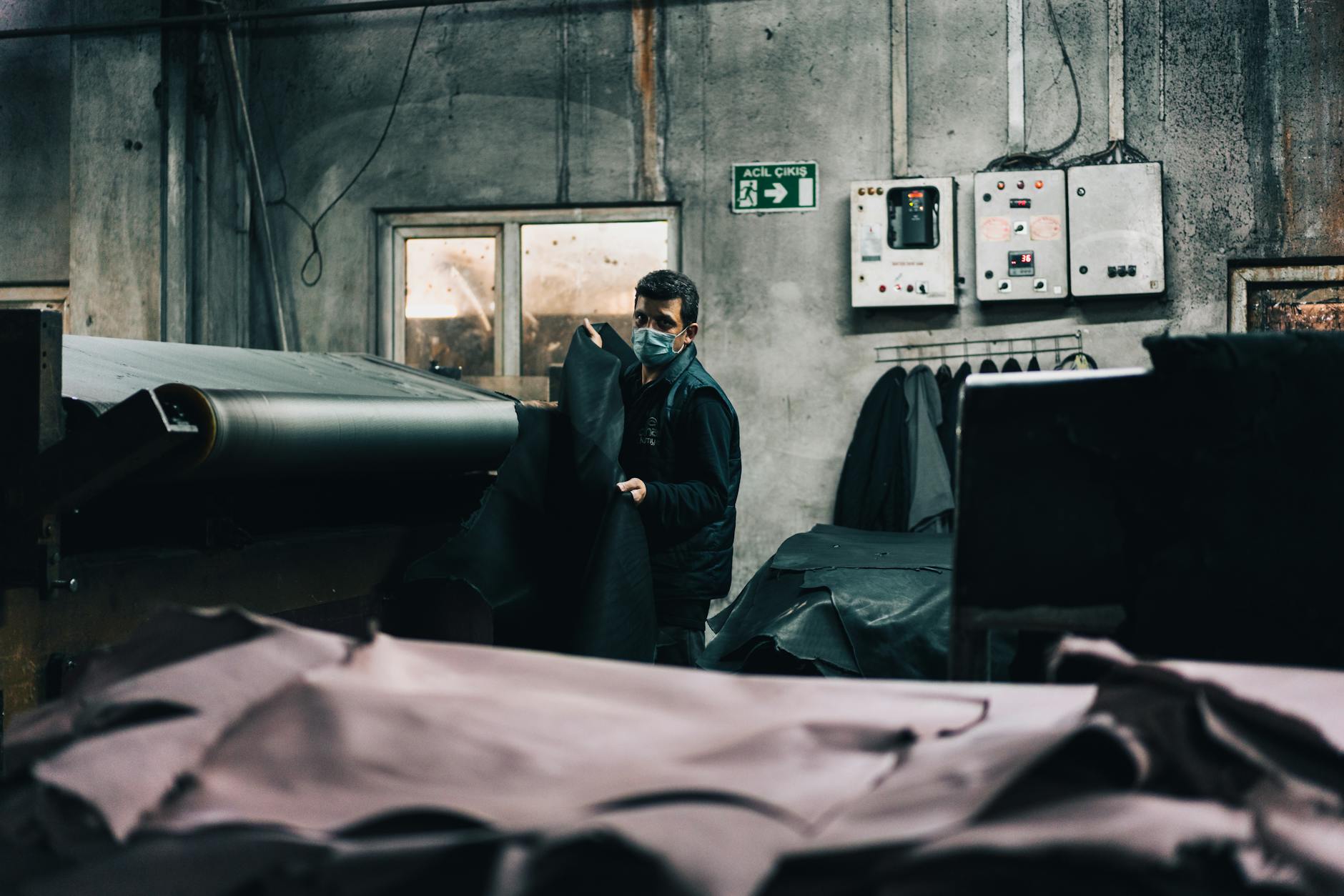 Artisan hands working with leather strips in a luxury goods atelier
