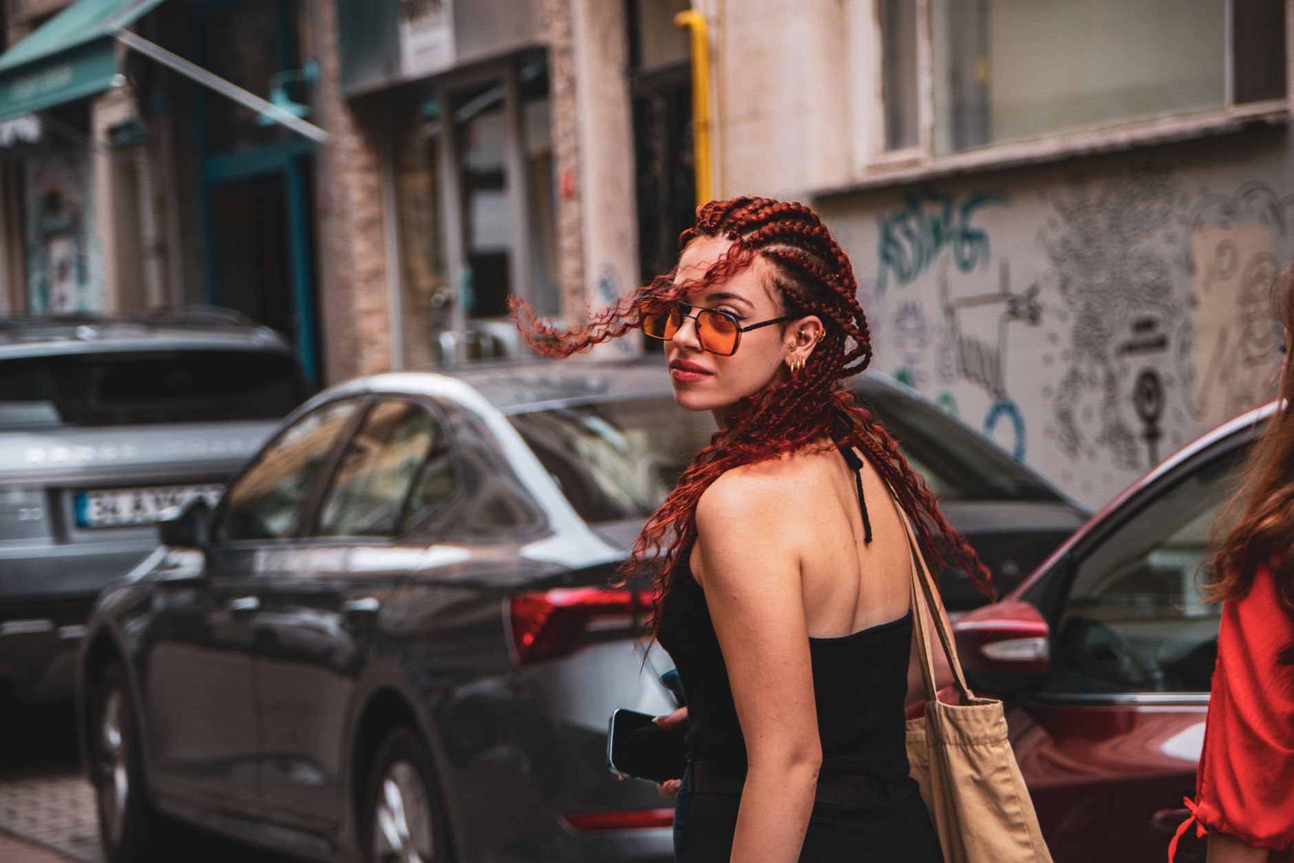 A stylish woman carrying a designer bag on a city street