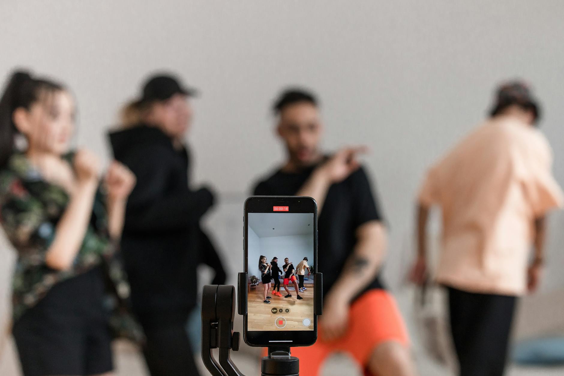 Person filming dance moves on smartphone in vertical orientation