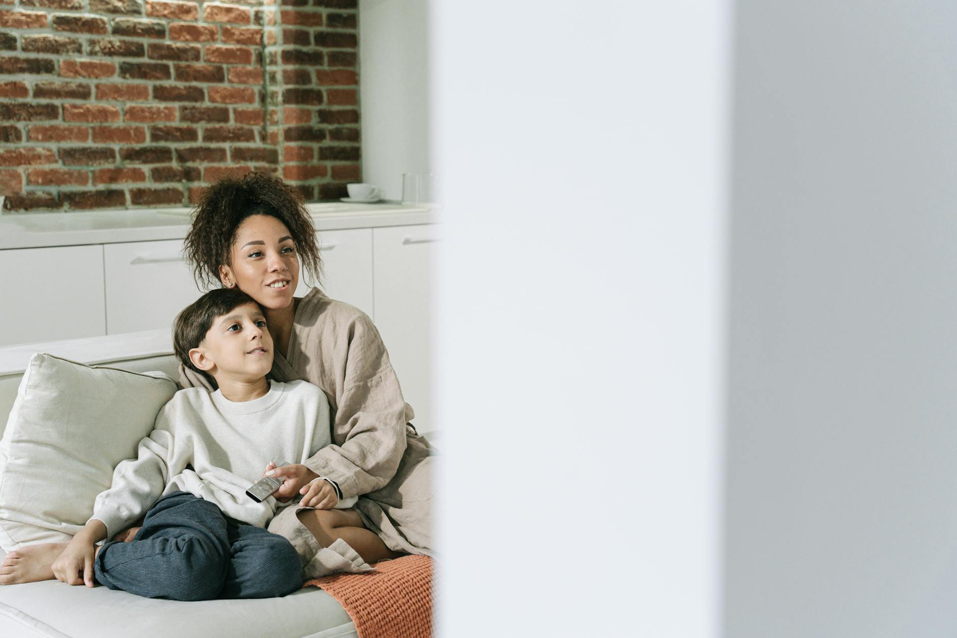Family sitting together on couch watching television in living room