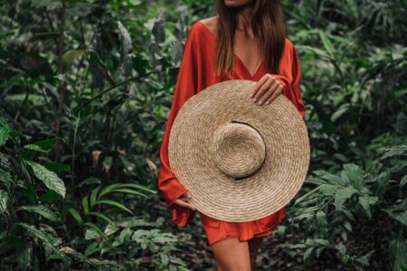 Jacquemus’ Oversized Hats Are Dividing Street Style Purists A woman wearing a dramatically wide-brimmed straw hat outdoors in natural light