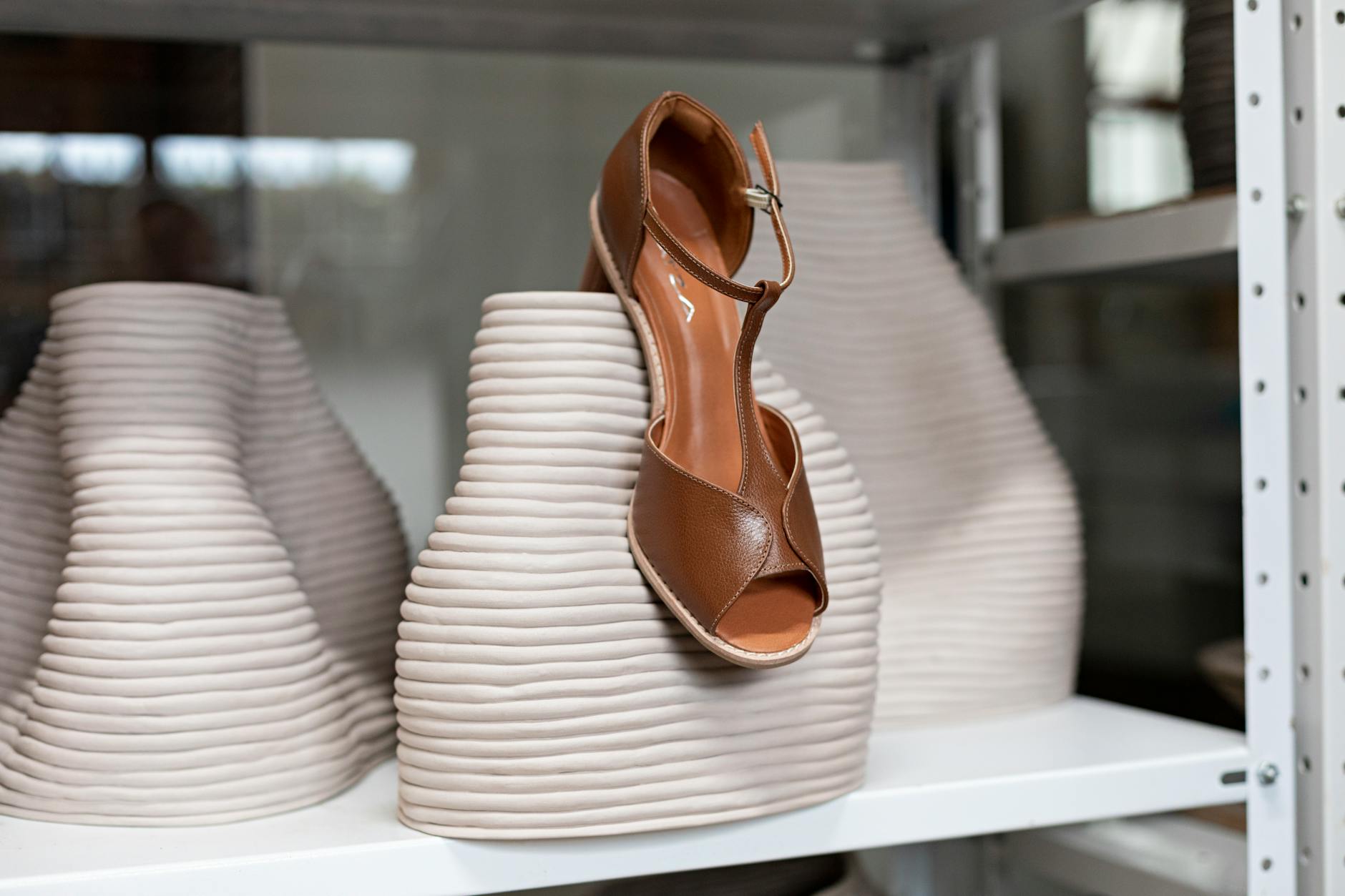 Close-up of a minimalist leather flat sandal on a clean surface