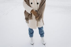 Acne Studios’ Scarf Coat Is Becoming Winter’s Unlikely Status Piece A person wearing an oversized wool wrap coat on a city street in winter