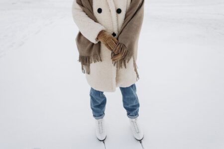 Acne Studios’ Scarf Coat Is Becoming Winter’s Unlikely Status Piece A person wearing an oversized wool wrap coat on a city street in winter