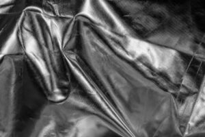 Issey Miyake’s Pleats Please Line Is Reclaiming Minimalist Wardrobes Close-up of finely pleated lightweight fabric in neutral tones