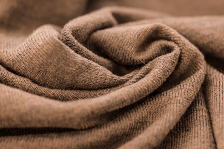 Freed from Logomania, Brunello Cucinelli Is Quietly Winning Folded cashmere sweaters in neutral tones arranged on a clean surface