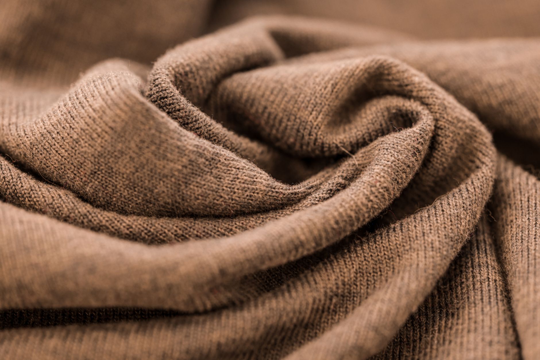 Folded cashmere sweaters in neutral tones arranged on a clean surface