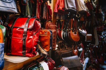 Structured designer handbags displayed on a minimalist shelf in a luxury boutique