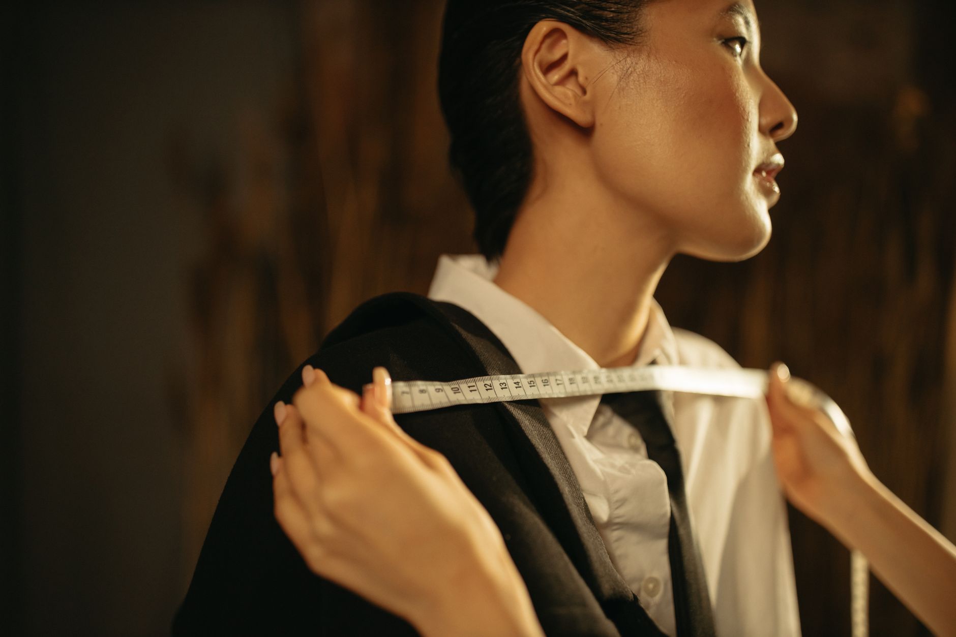 Woman in a sharp tailored blazer and trousers, styled with minimal accessories