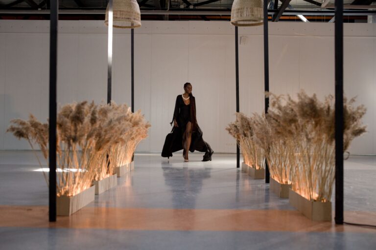 Model walking a fashion runway in a flowing feminine outfit