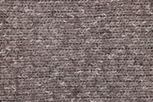 Close-up of textured knitted boots with structured sole, displayed on a clean surface