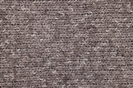 Close-up of textured knitted boots with structured sole, displayed on a clean surface