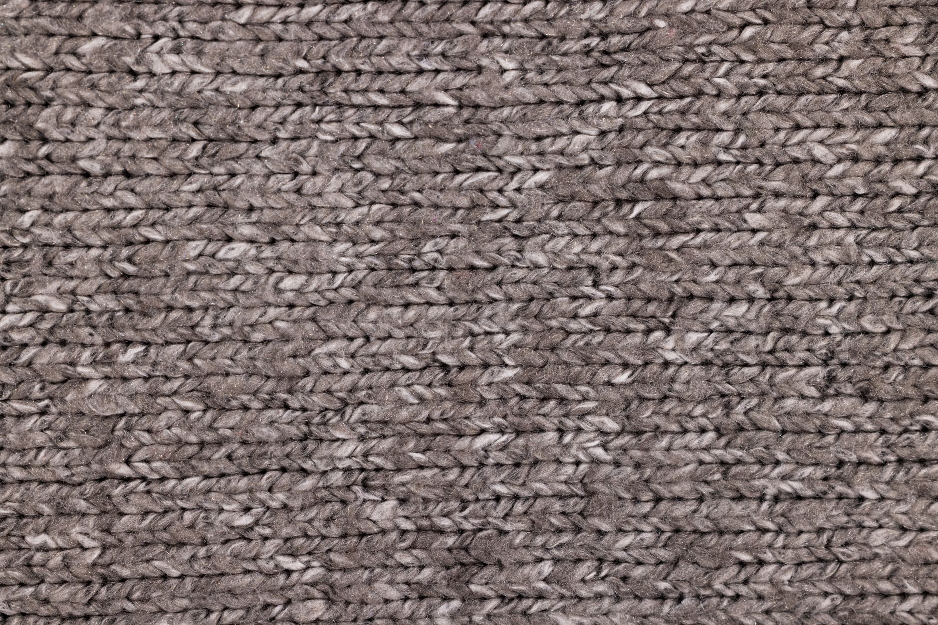 Close-up of textured knitted boots with structured sole, displayed on a clean surface