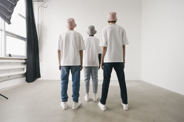 Neatly folded neutral-toned basics including a white shirt and stone trousers on a clean surface
