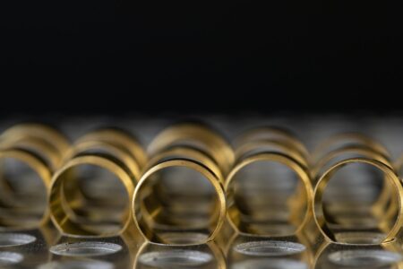 Multiple thin gold stacking rings arranged together on a neutral surface