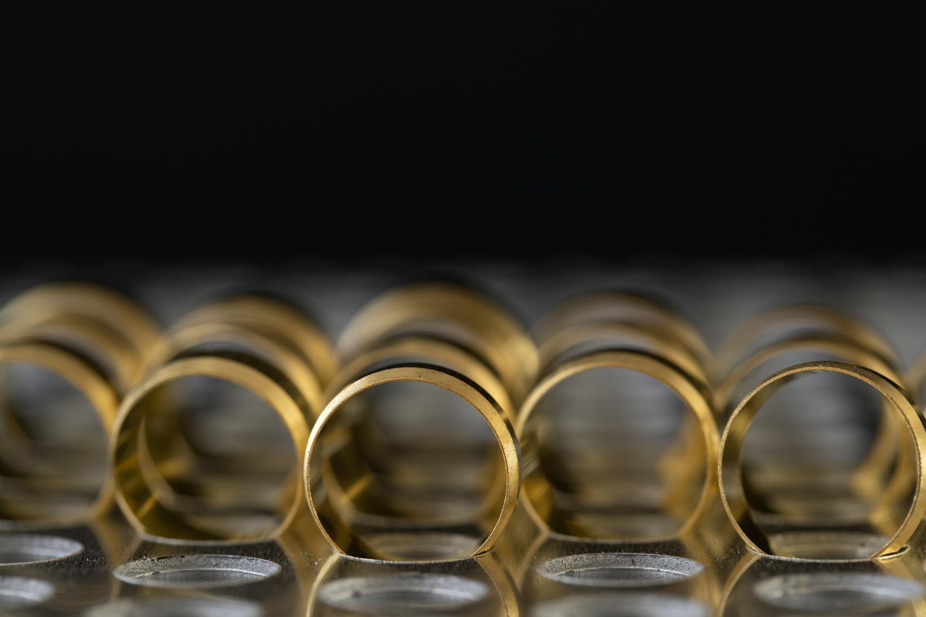 Multiple thin gold stacking rings arranged together on a neutral surface