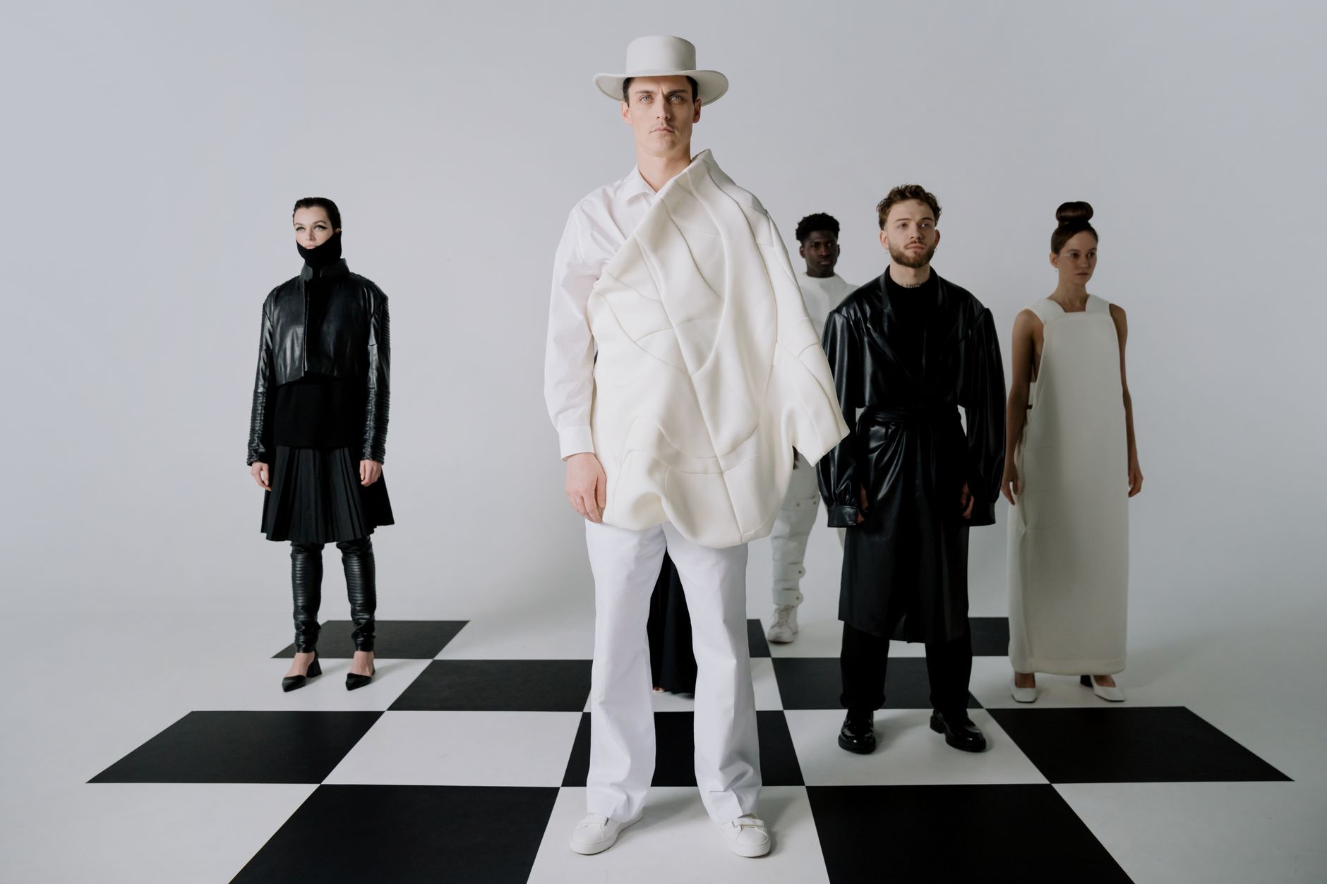 Fashion observers reviewing clothing at a runway show, representing critical reaction to new collections