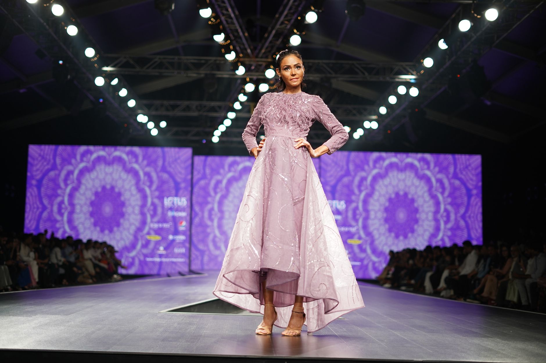 Model walking a high-fashion runway wearing structured leather garments