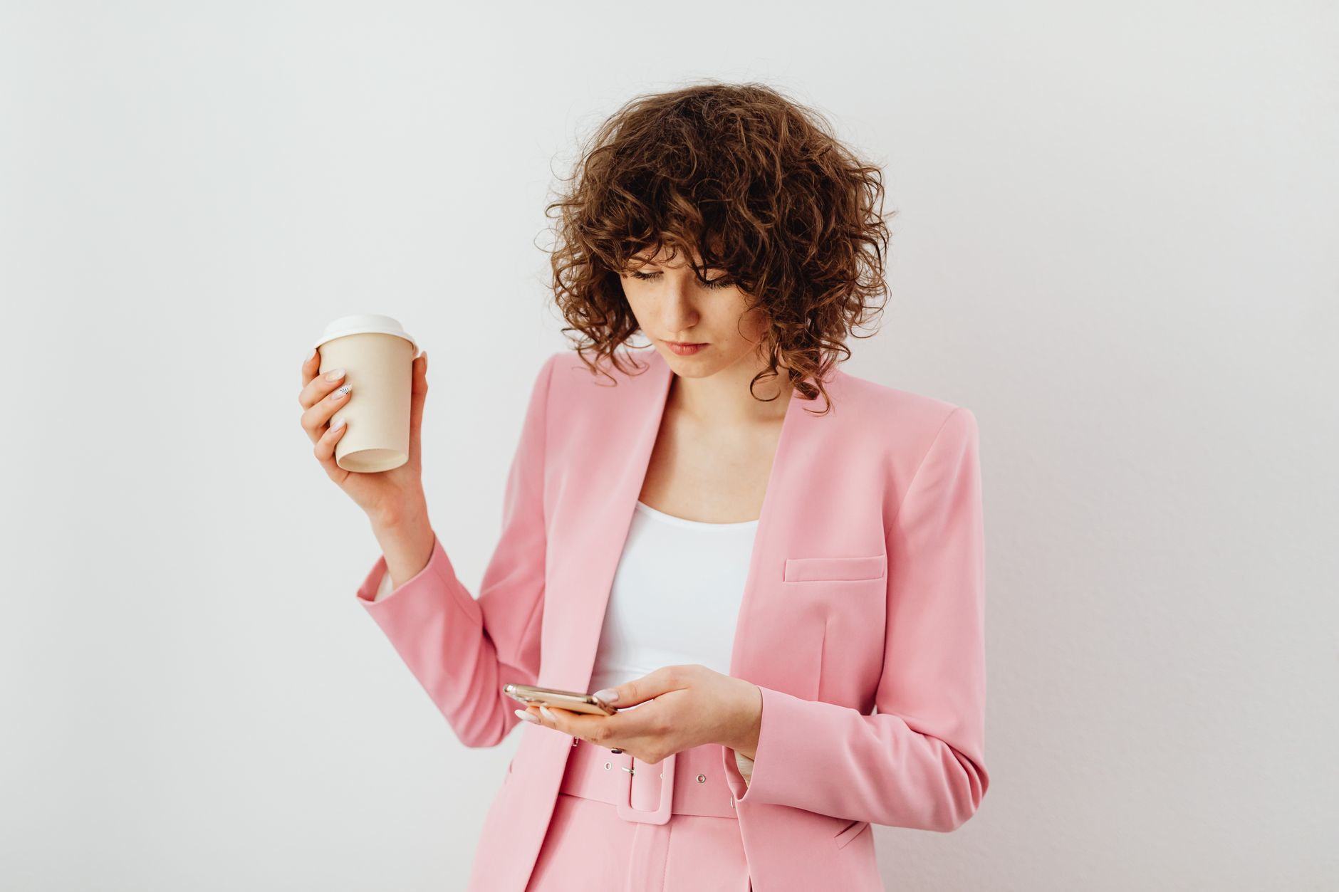 A professional woman in a structured jacket walking through a modern office environment