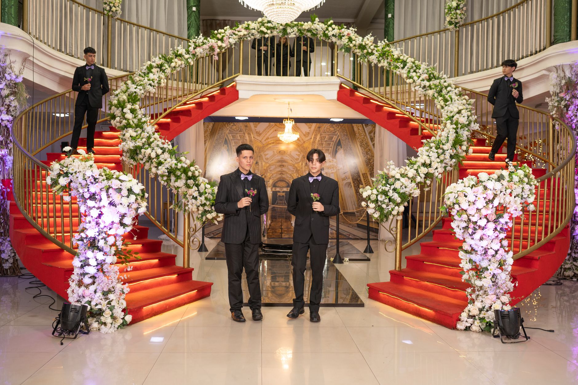 Celebrities and stylists gathered at a formal red carpet event with photographers lining the entry