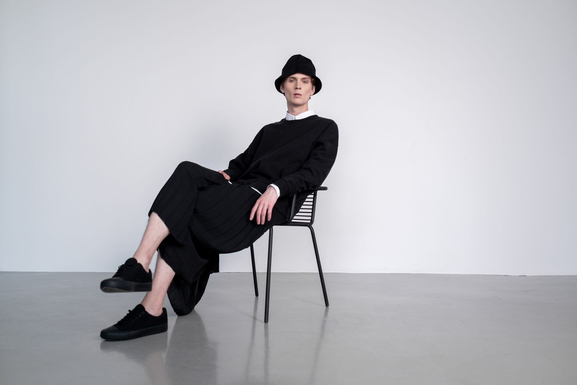 Model wearing loose, minimalist clothing in a clean editorial setting
