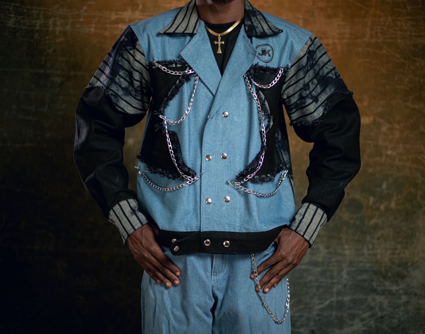A man wearing a slim jacket layered over a turtleneck sweater in an urban setting