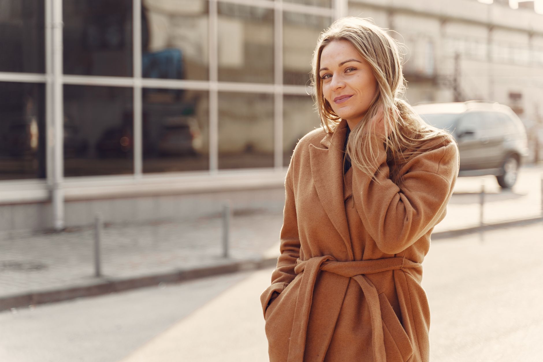 A woman in understated, high-quality clothing walking on a city street