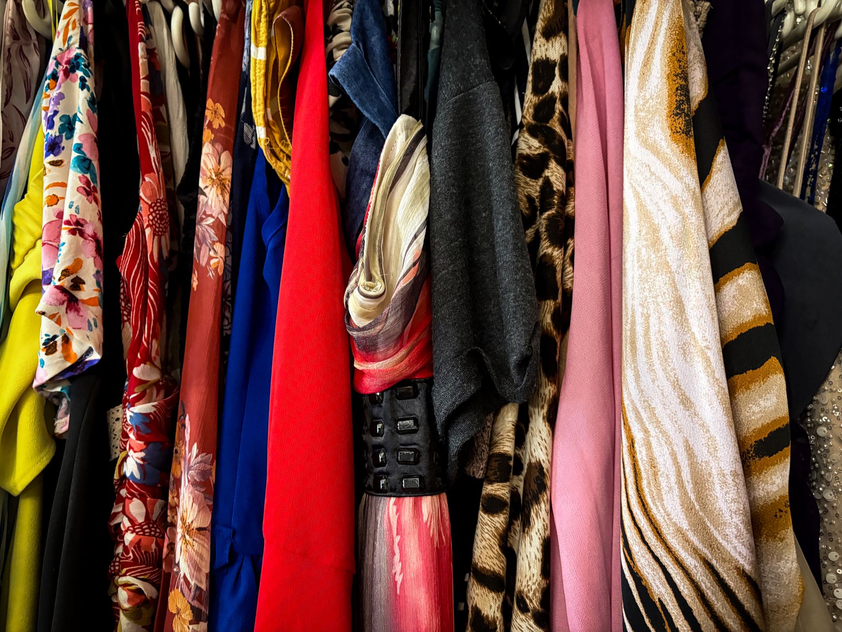 Curated secondhand luxury clothing displayed on a retail rack