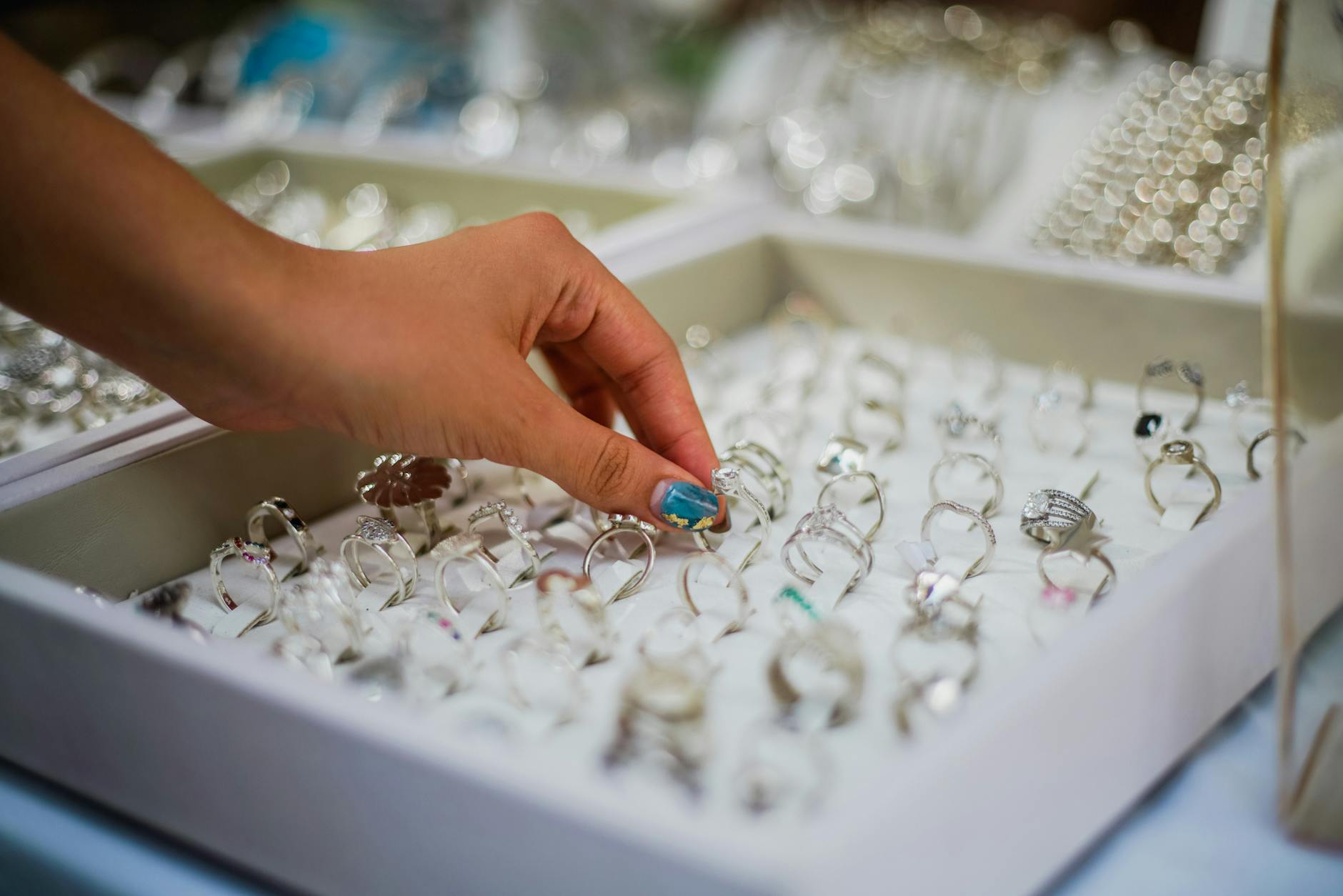 Close-up of a woman's hands wearing multiple delicate gold rings on different fingers