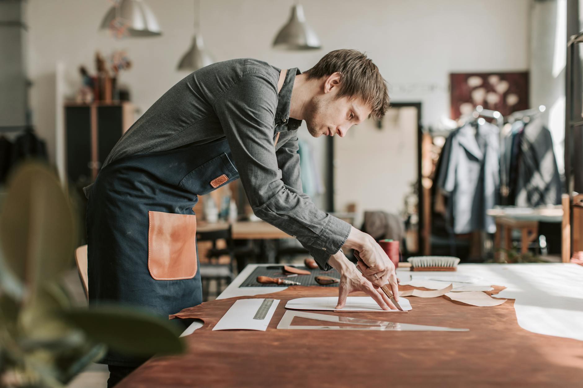 Artisan hands working with strips of leather in a traditional craft workshop