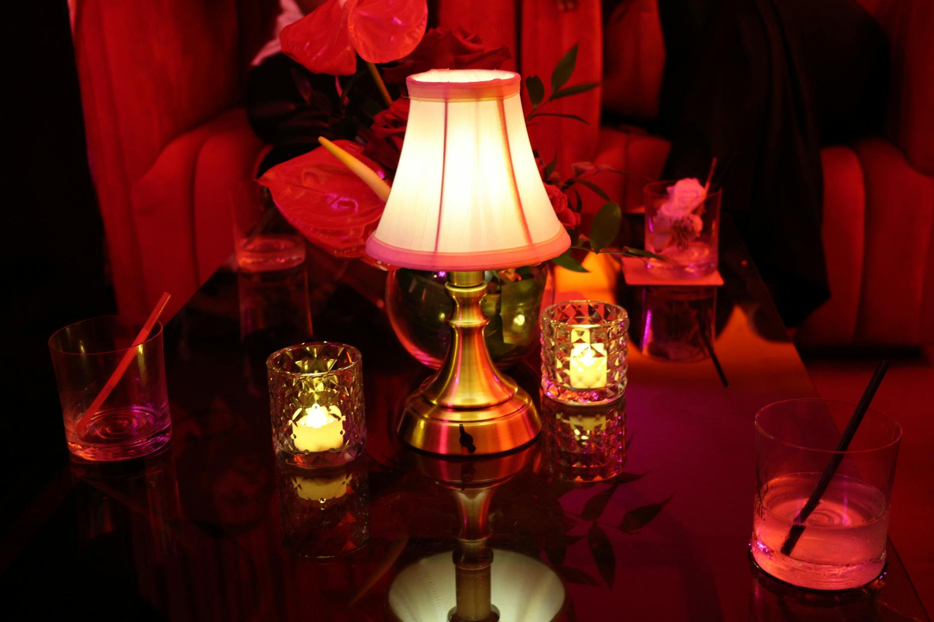 People relaxing and talking in a dimly lit lounge space with warm ambient lighting