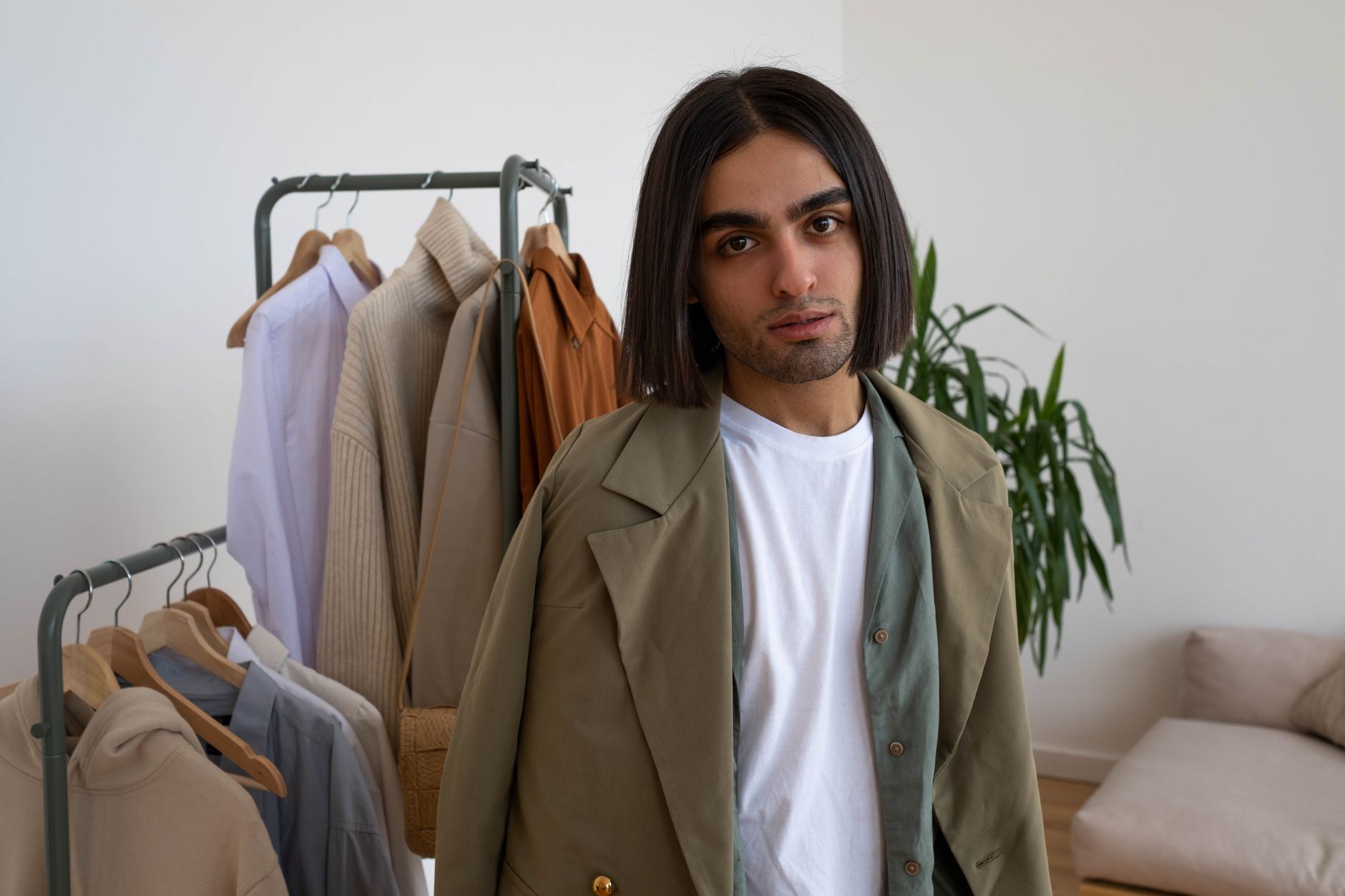 Man in neutral-toned tailored clothing standing in a clean, minimal interior
