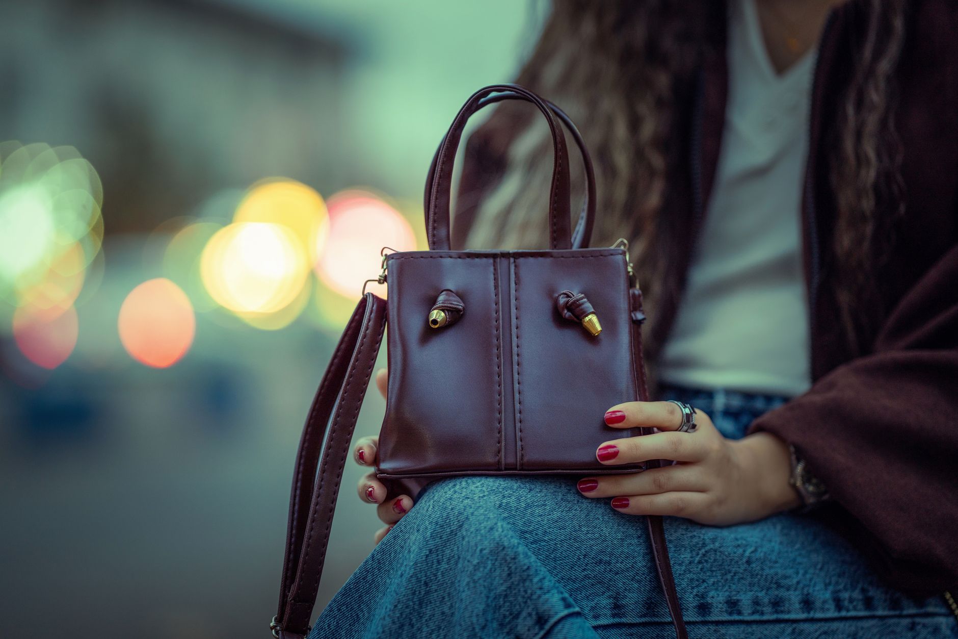 Woman carrying a structured leather handbag, illustrating understated Italian style