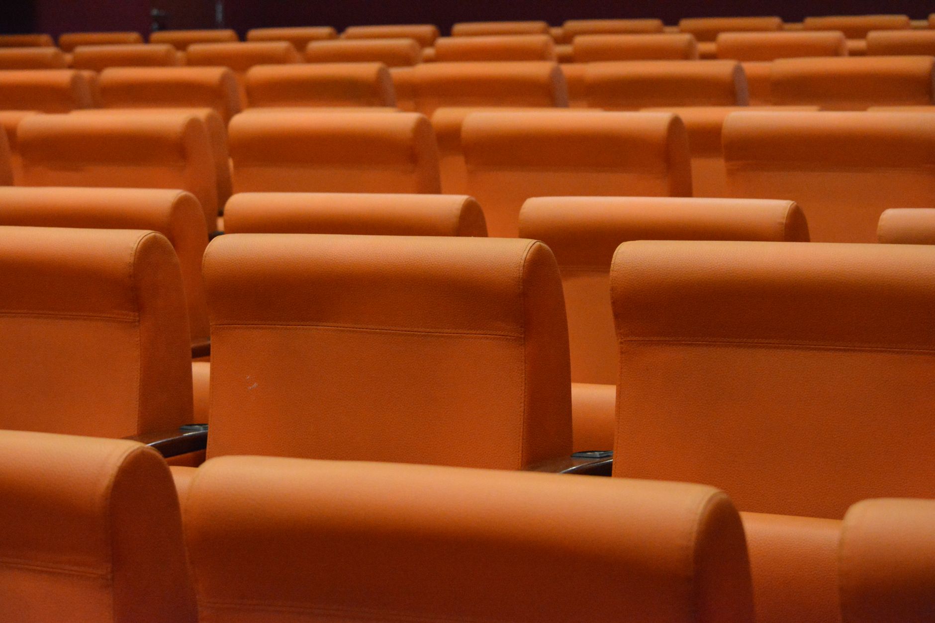 Empty seats inside a classic movie theater with screen illuminated