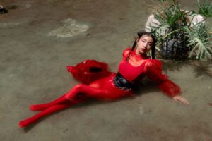 A bold red fashion editorial look showcasing luxury garment construction and fabric quality