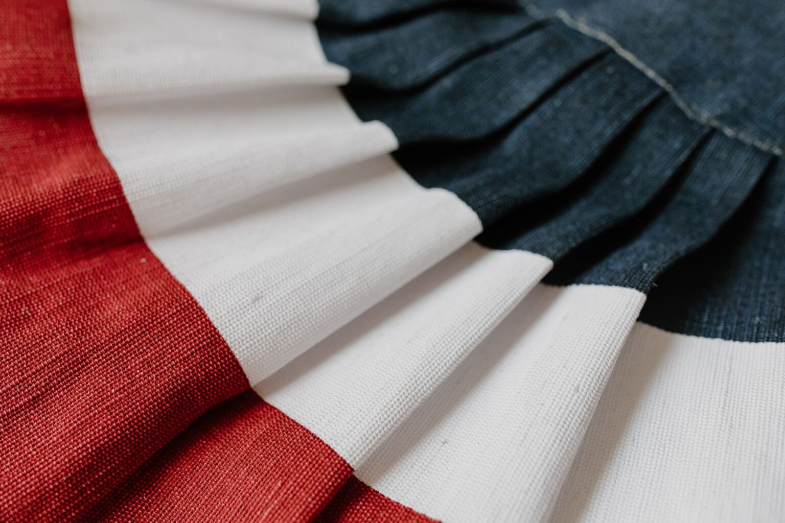 Issey Miyake’s Pleats Please Is Quietly Outlasting the Structured Silhouette Close-up of pleated polyester fabric showing structured fold detail