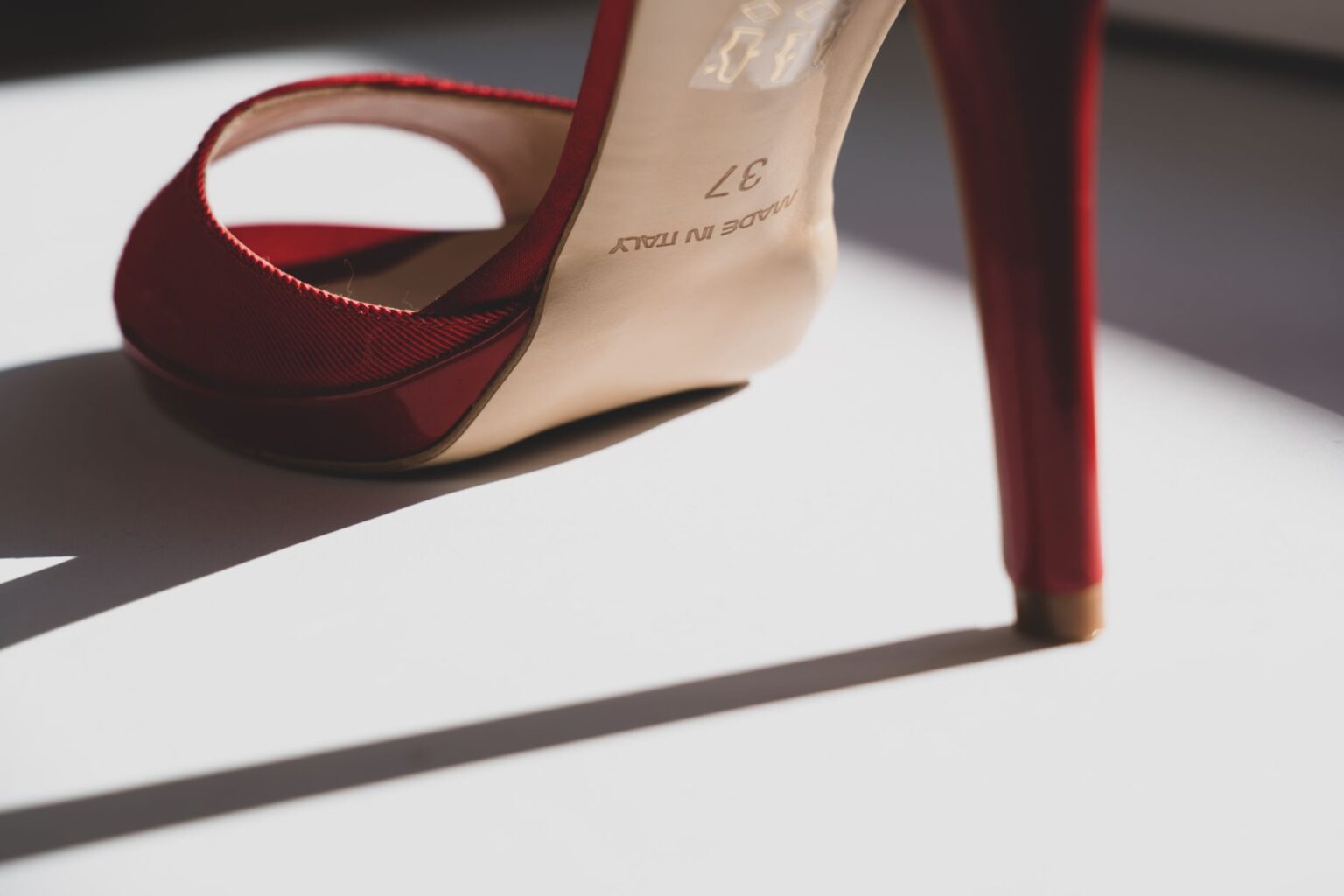 Versace’s Medusa Heel Is Quietly Outlasting the Platform Moment Close-up of a pair of elegant stiletto heels with gold hardware detail against a neutral background