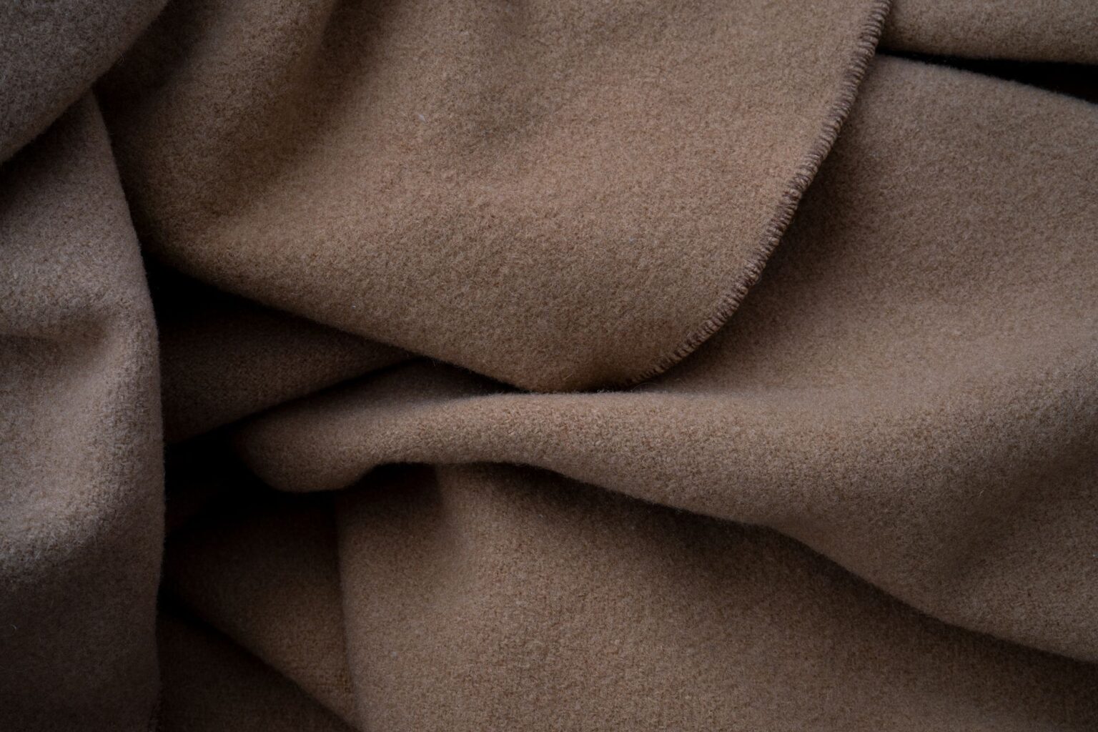 Loro Piana’s Cashmere Bomber Is Quietly Edging Out the Overshirt Close-up of a soft cashmere fabric in a neutral tone, showing fine texture and quality