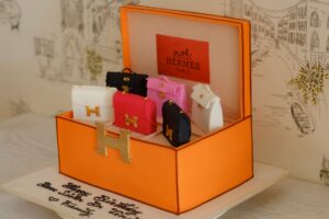 Loro Piana’s Wish Bag Is Quietly Unseating the Clutch A small structured leather top-handle bag in a neutral tone, representing quiet luxury accessory design