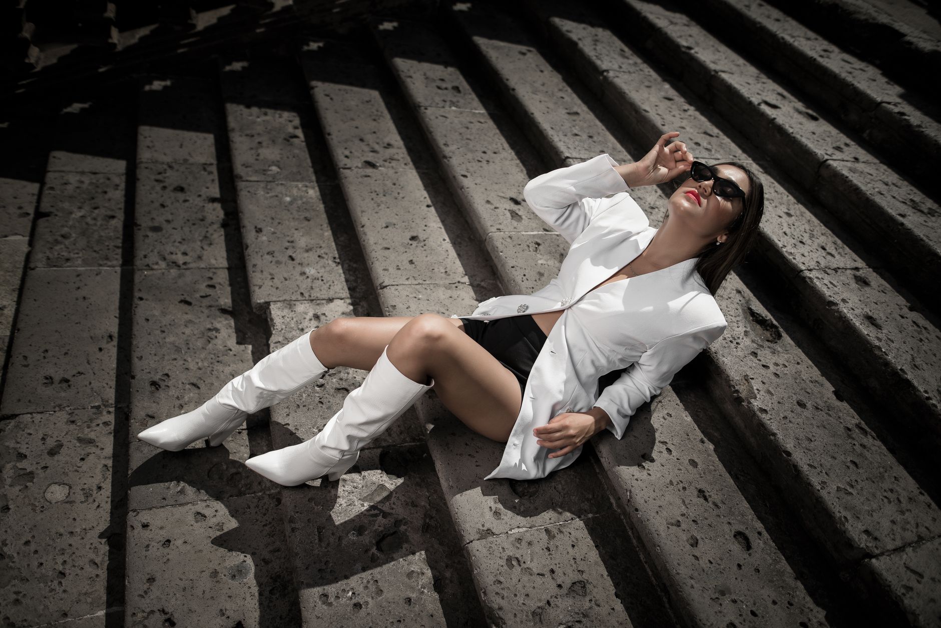Editorial fashion photograph featuring styled calf-height boots with tailored trousers