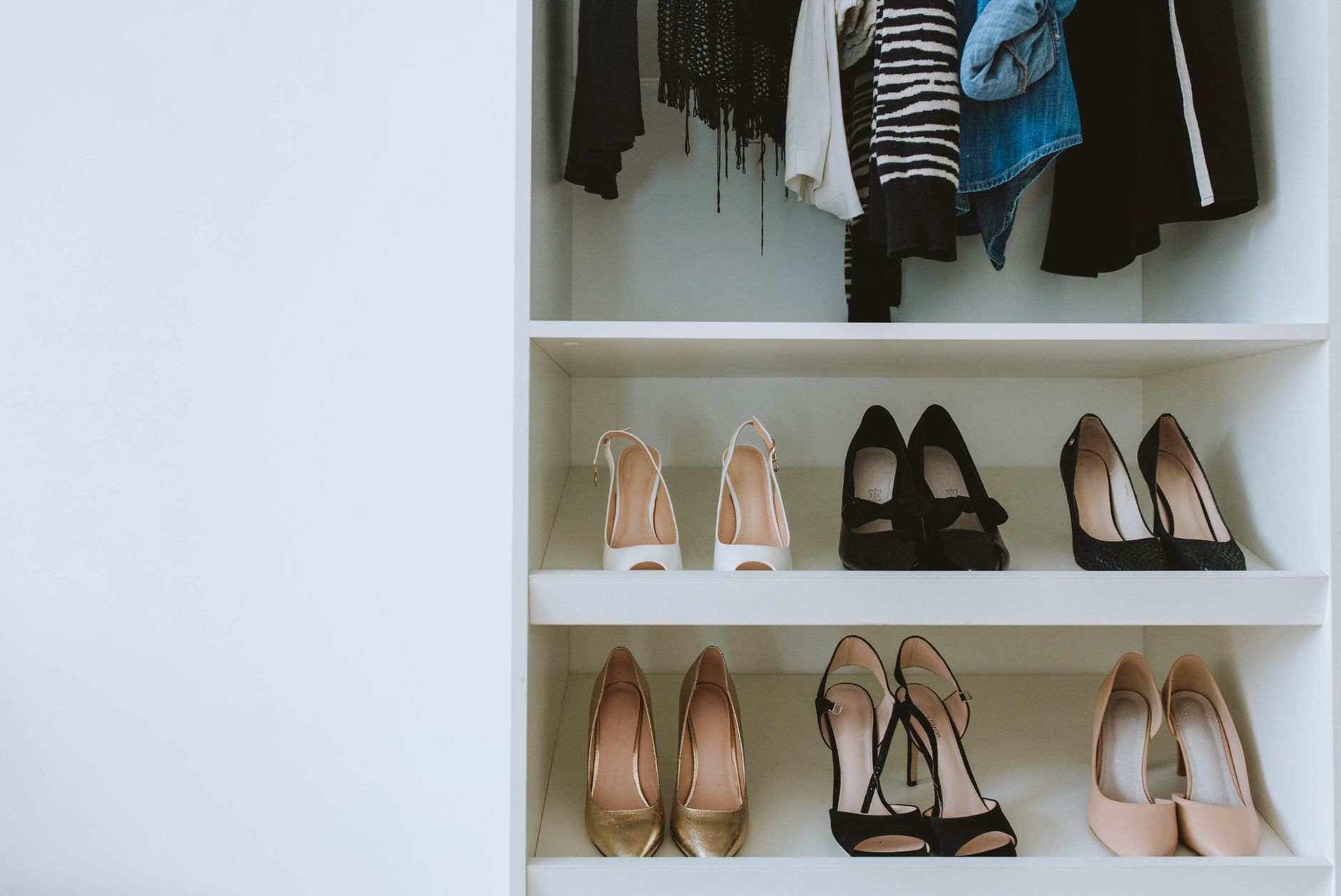 Organized luxury shoe collection on shelves in a fashion closet