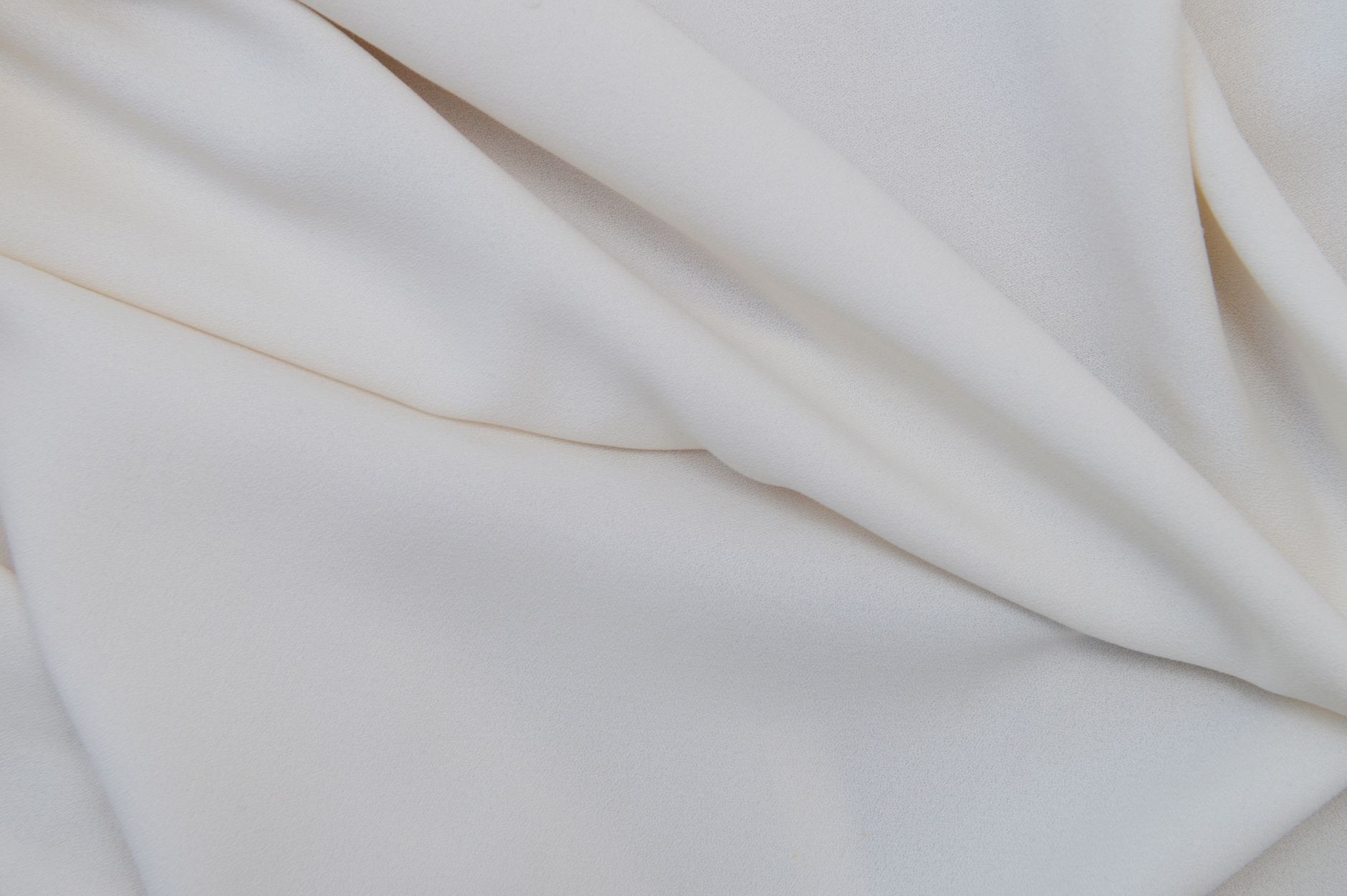 Close-up of soft cashmere fabric in neutral tones showing fine texture and quality