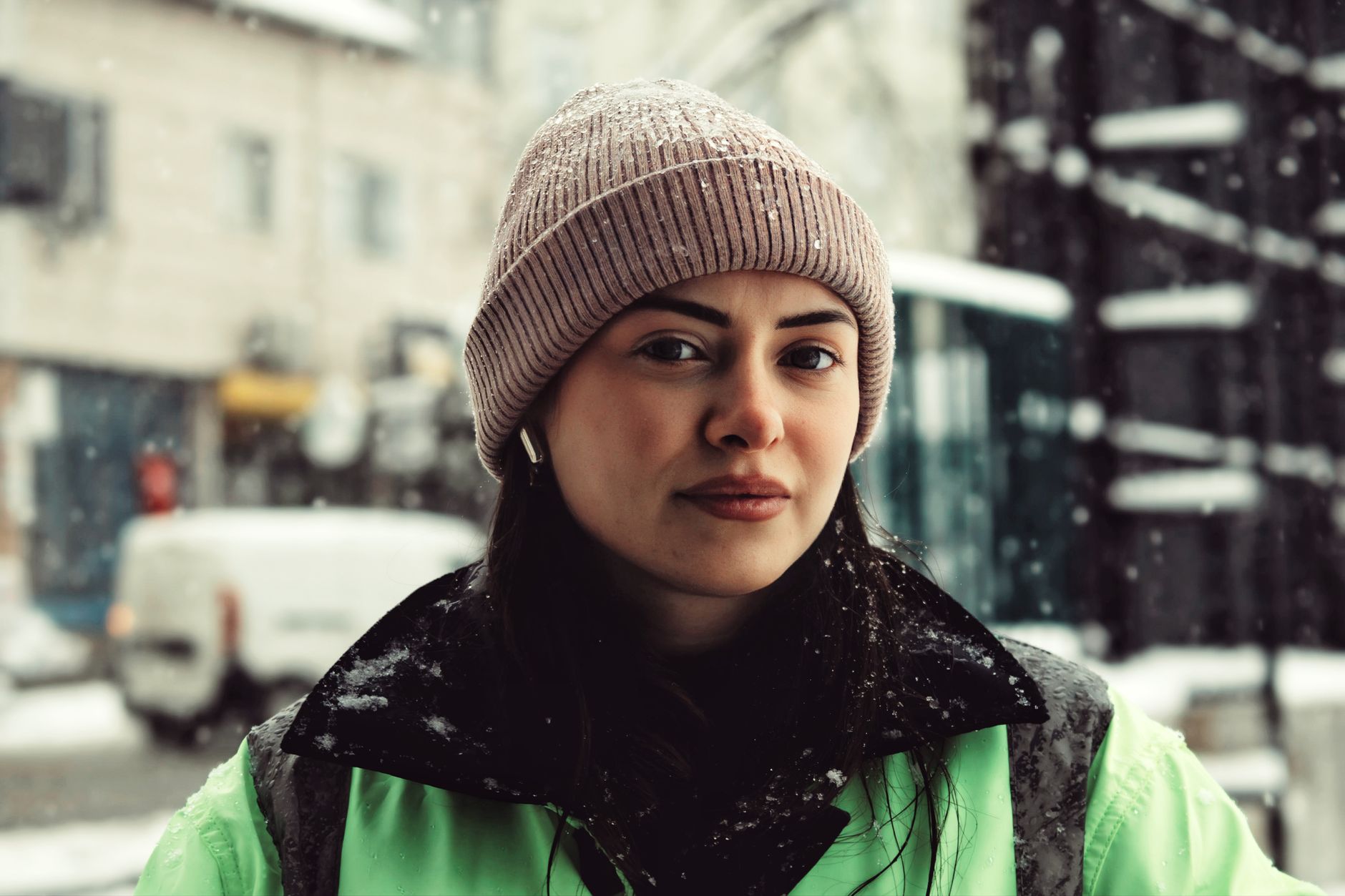 A person wearing a tailored long coat walking on a city street in winter
