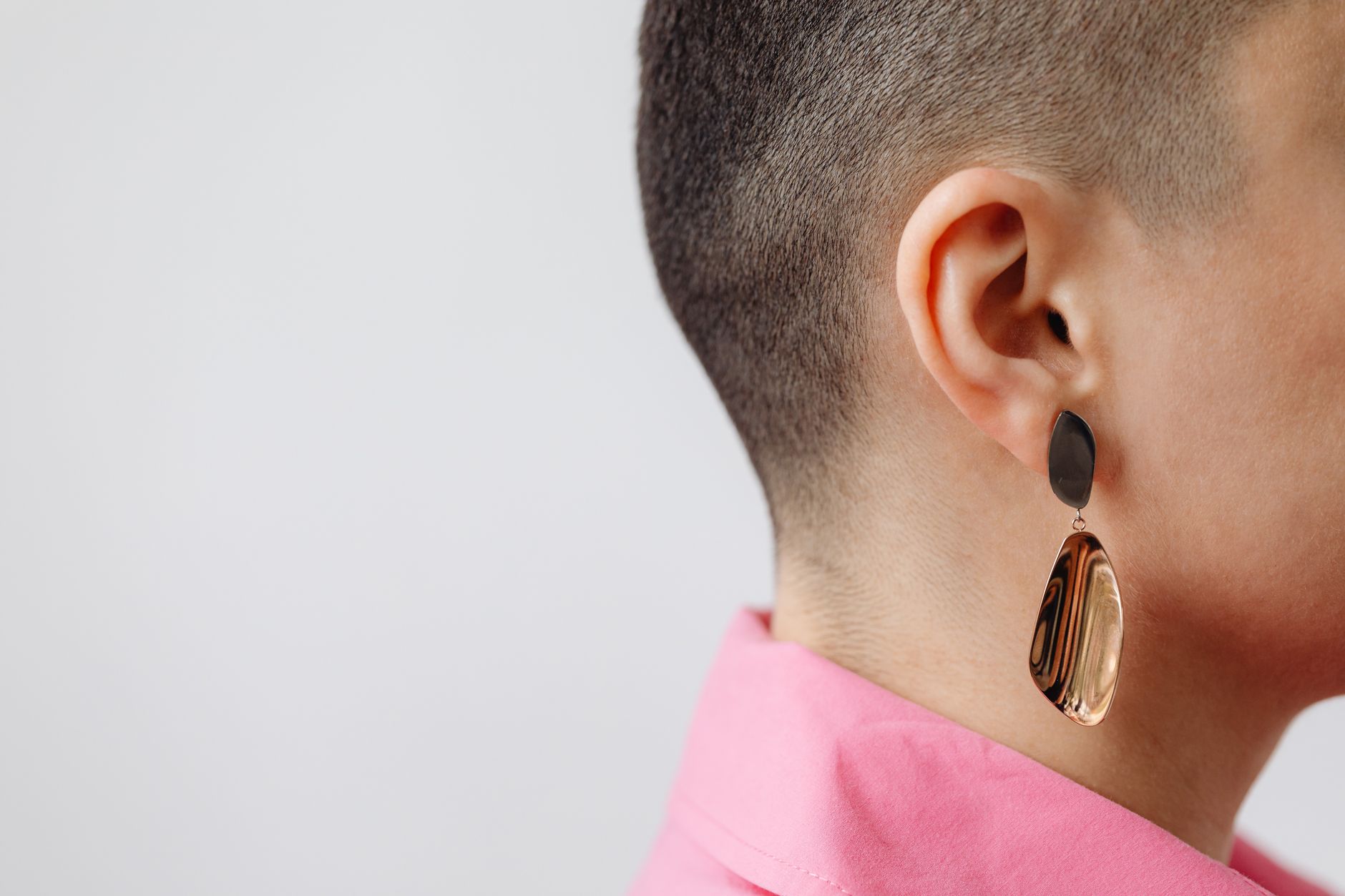 Woman wearing statement drop earrings with a clean, minimal outfit