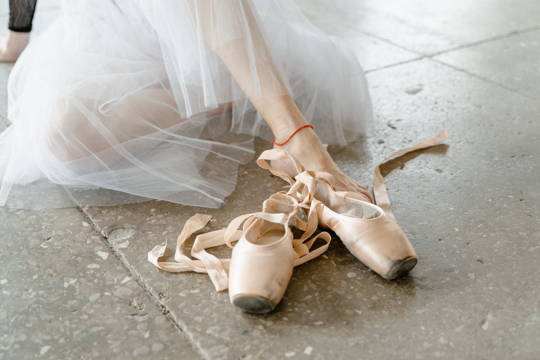 Broken-in satin ballet pointe shoes showing natural wear and distressing