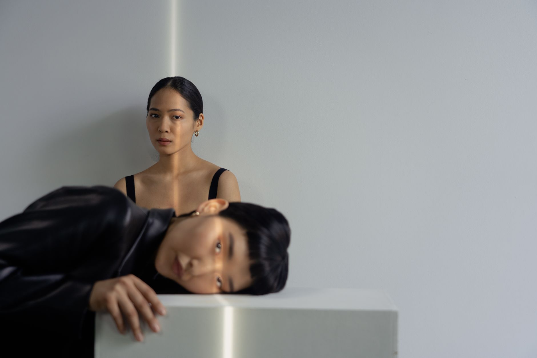 A minimal fashion studio setting with garments displayed in an austere, clean environment