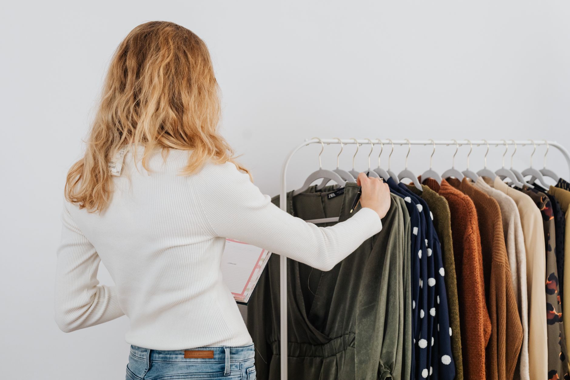 Neatly arranged white and neutral-toned wardrobe pieces on a clothing rack